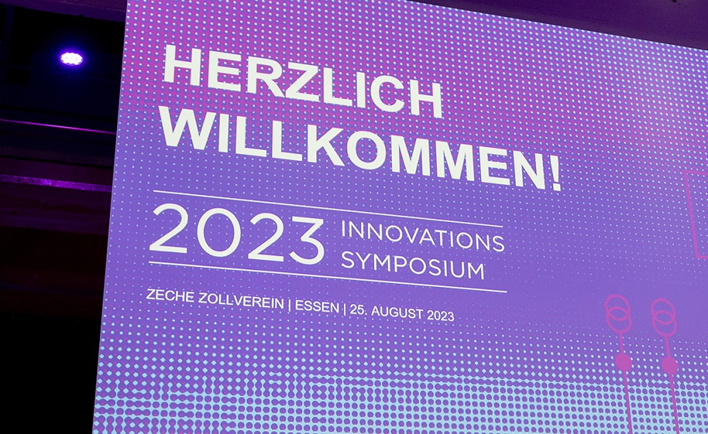 Beschreibung: Die lila angestrahlte Bühne des Amprion Innovationssymposiums 2023.